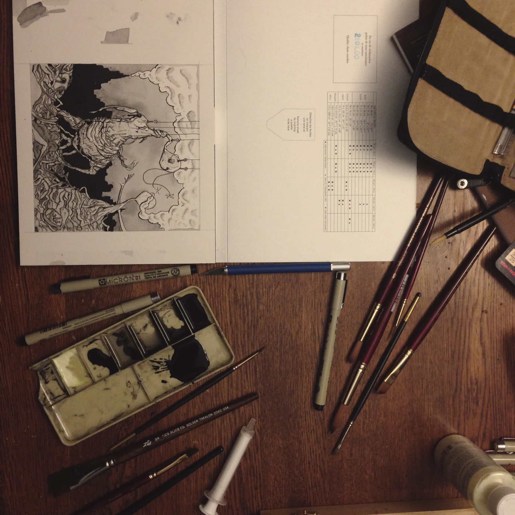 Ink, brushes and a sketchbook on the desk
